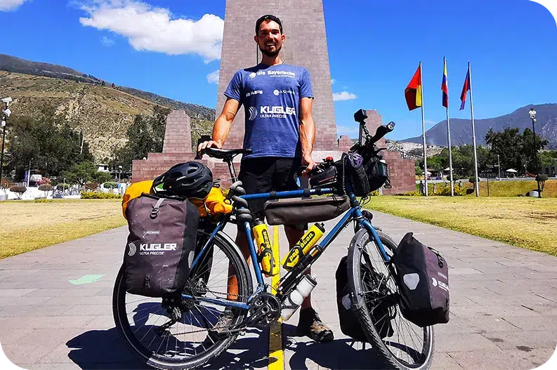 Abenteurer Darius Braun auf Panamericatour mit vollbepacktem Fahrrad in der Sonne stehend