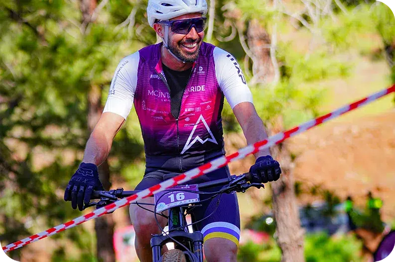Glücklicher Mountainride-Rennfahrer fährt mit Mountainbike über die Ziellinie