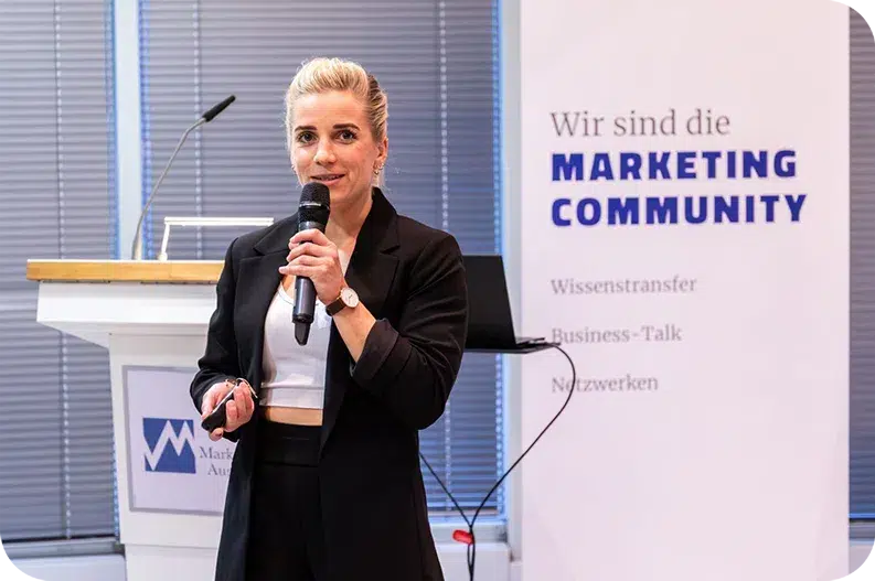 Boxweltmeisterin und Speakerin Tina Rupprecht mit Mikrofon auf der Bühne